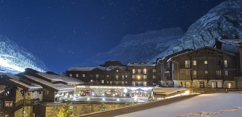 Club Med Val d'Isère, en France - Vue extérieure  avec la montagne en arrière-plan la nuit.