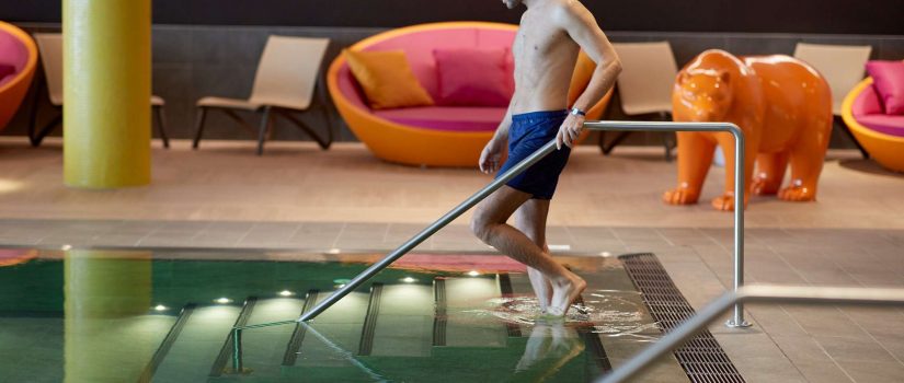 Image d'un homme descendant les marches de la piscine d'intérieur