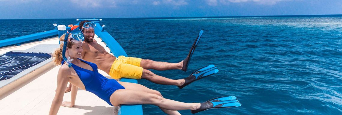 Club Med Villas de FInolhu, aux Maldives - Photo d'un couple sur un bateau s'apprêtant à plonger avec masques et tuba