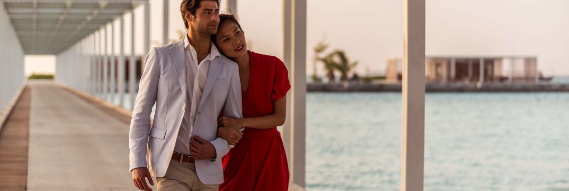 Club Med Villas de FInolhu, aux Maldives - Photo d'un couple marchant sur un ponton devant la lagune