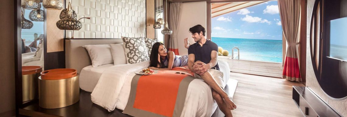 Club Med Villas de FInolhu, aux Maldives - Photo d'un couple dans une chambre d'une villa avec vue sur la lagune