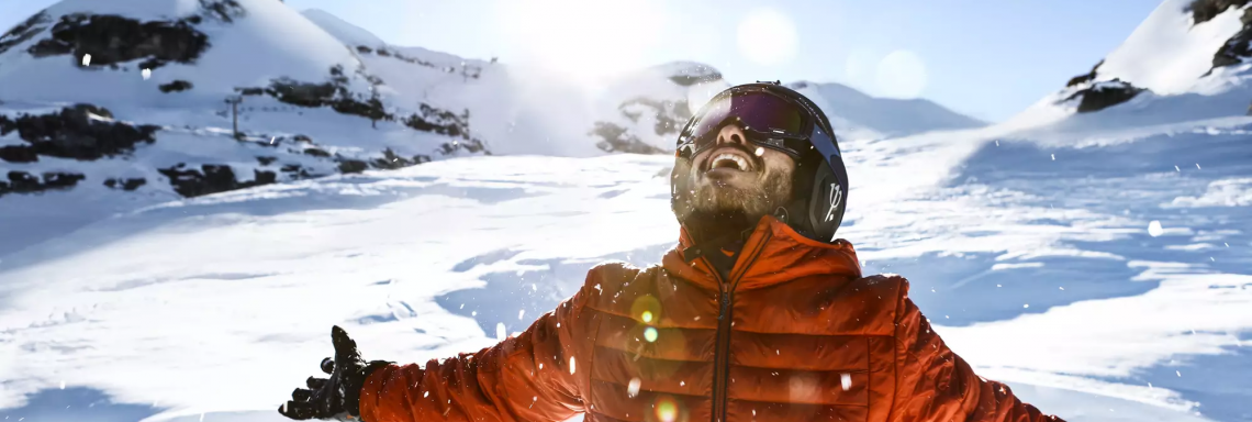 Photo d'un homme souriant dans un paysage de montagne enneigée