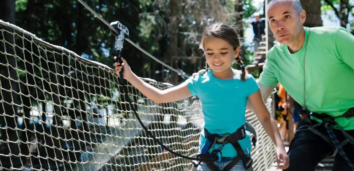 Club Med Samoëns, en France - Une jeune fille et son G.M, pratique un des sports de grimpe offert par Club Med